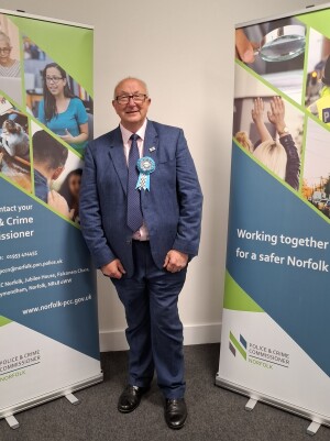 PCC Colin Sutton standing between two banners