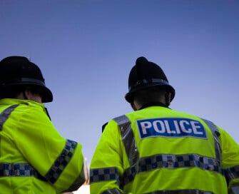 the back of two officers wearing high visibility jackets