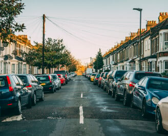 centre of urban street with cars parked either side of road