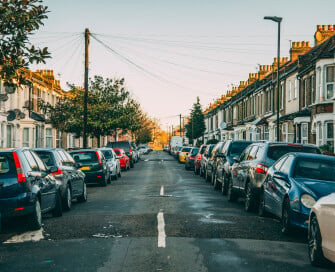 centre of urban street with cars parked either side of road