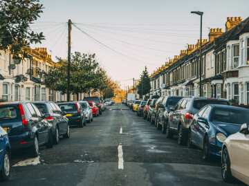 centre of urban street with cars parked either side of road