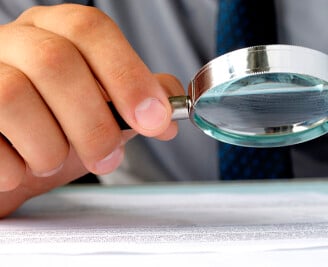 Hand holding a magnifying glass