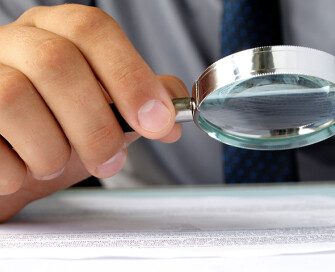 Hand holding a magnifying glass