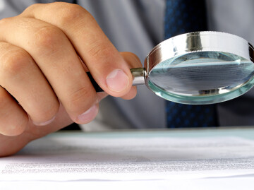 Hand holding a magnifying glass