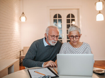 Mature couple looking at laptop at table