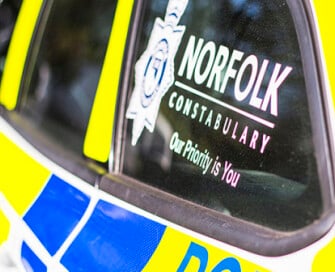 Side of police car with Norfolk Constabulary logo