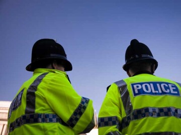 Backs of two police officers wearing high visibility jackets