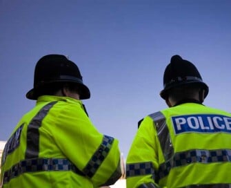 Backs of two police officers wearing high visibility jackets