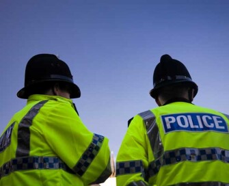 Backs of two police officers wearing high visibility jackets