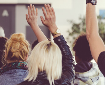 Back of group of people with hands up