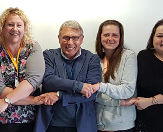 Former PCC Lorne Green holding hands with group of female project workers